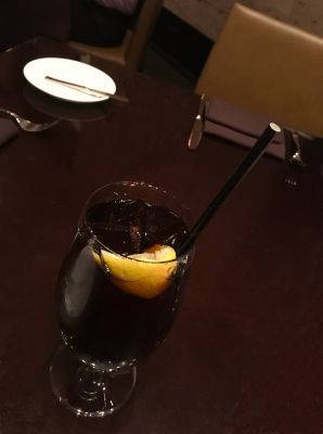 paper straw in a glass of coke with a piece of lemon