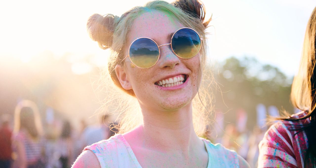 Веснушчатая блондинка в солнцезащитных очках с прической «бублики».