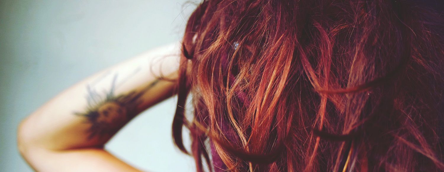 Donna con capelli voluminosi di diverse sfumature di rosso e viola