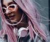 Asian woman with pink hair wears ear phones and sunglasses 