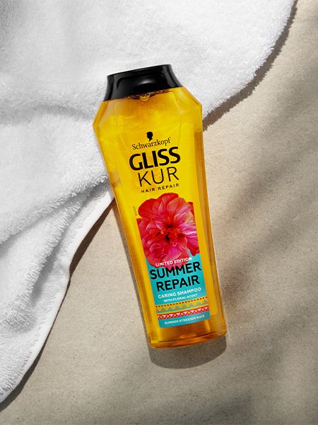 Gliss Kur Summer Repair Caring Shampoo lies on a white towel and beige surface