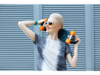 Woman with short white hair holding a skateboard