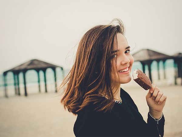 Kobieta na plaży jedząca loda