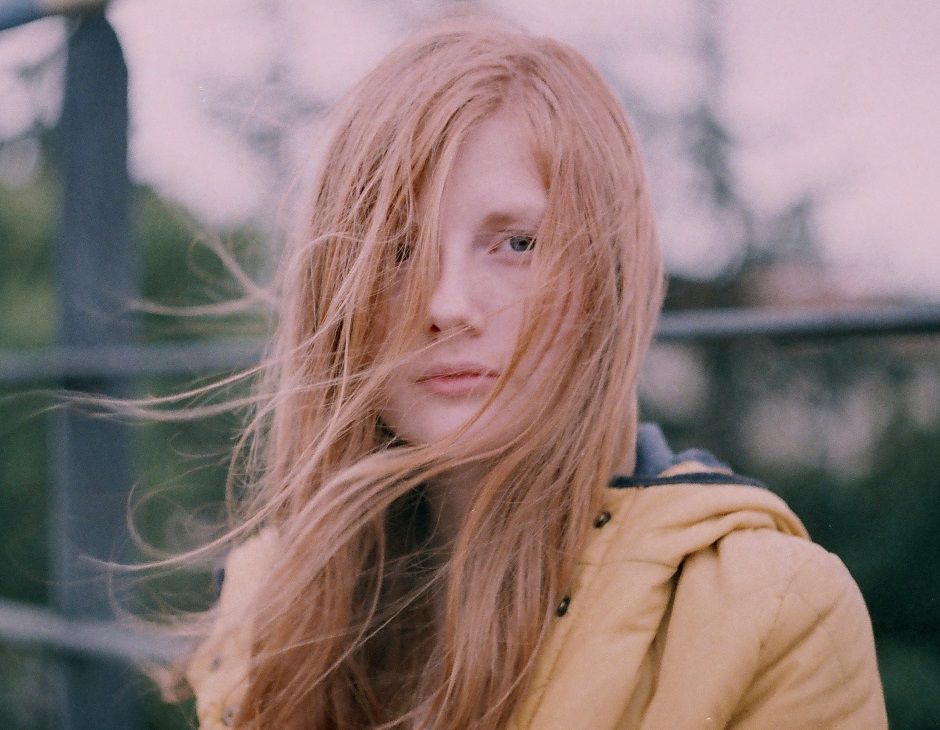 Jeune femme au visage balayé par de longs cheveux blond miel