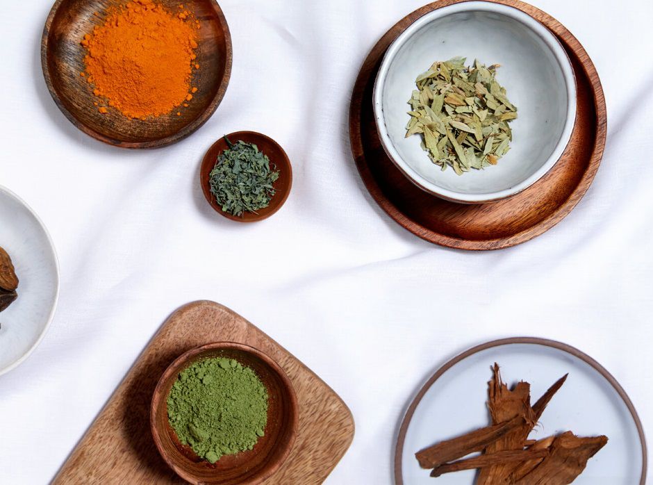 Photos de différentes poudres colorées dans des bols en bois sur un fond blanc