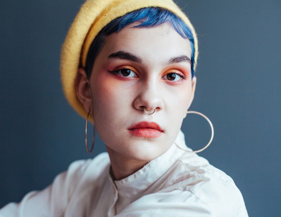 Femme avec un béret jaune et des cheveux bleus coupés courts