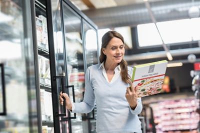 Woman looking at a box of frozen pizza