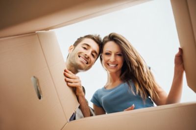 couple of man and woman opening a cardboard box used for moving