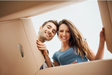 一对男女打开用来搬家的纸板箱。
