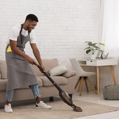 person cleaning the living room carpet with a vacuum cleaner