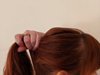Red-haired woman making a ponytail