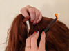 Red-haired woman pushing a banana clip into her hair