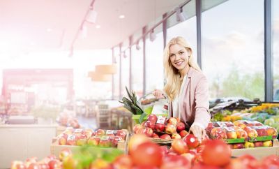 Iniciativa “Embalajes seguros para alimentos” de Henkel: mujer comprando manzanas con pegatinas