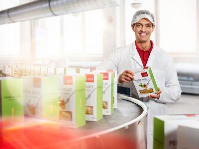 production line manger standing next to a line with manufactured pasta paper cartons with window