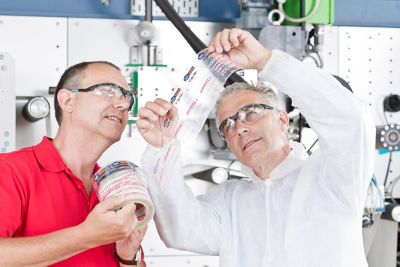 Deux hommes observent l’étiquette d'une bouteille