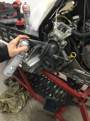pulverização do desengordurante pro strength LOCTITE® SF 7611 dentro de uma caixa de corrente de uma moto de neve