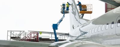 Deux techniciens de maintenance travaillant sur l’empennage d’un avion