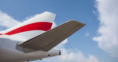 Imagen recortada de la cola de un avión con el cielo de fondo.