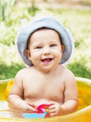 Lächelndes Baby in einem Plantschbecken.
