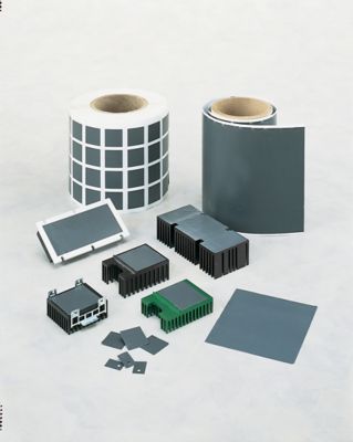 Photo of grey bergquist phase change thermal interface material on spools and applied to components of various shapes and sizes represents an effective alternative to thermal greases