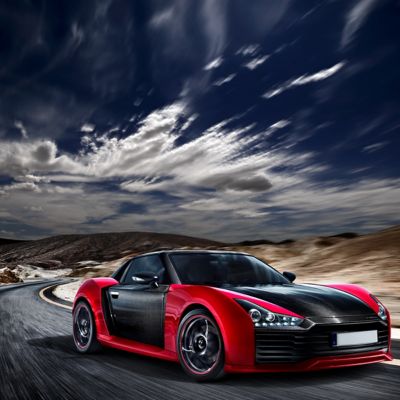 Red and Black Roding Roadster driving fast through mountains