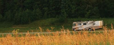 Recreational Vehicle Driving On The Road With Trees in Background