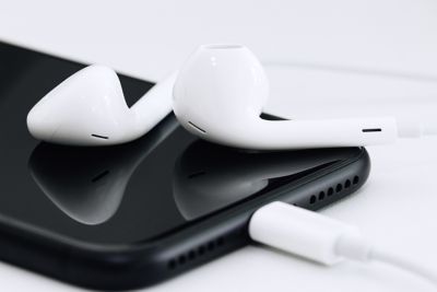 Auriculares blancos conectados a un teléfono negro