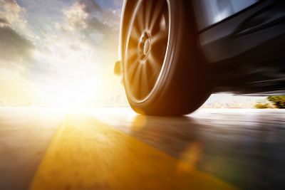 Close up of vehicle tire driving fast at sunset