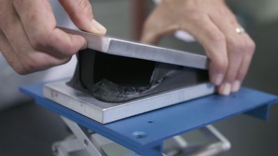 Henkel Engineer servicing a battery pack and removing the gasketing, pulling it appart