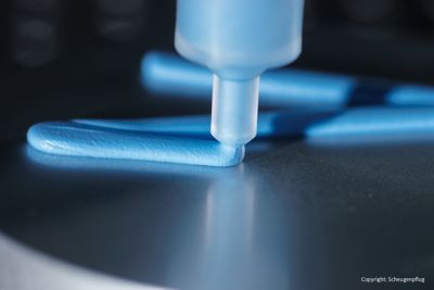 Close up of Scheugenpflug blue thermal interface material dispensing