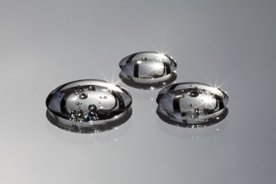 Closeup of three shiny droplets of automotive cleaner