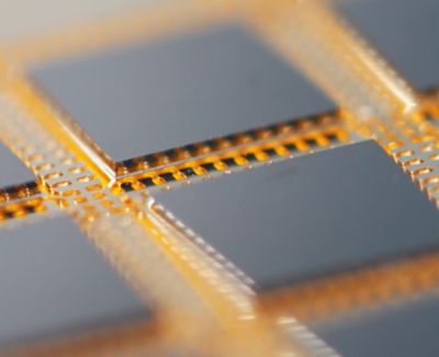 Closeup photo of copper leadframe packaging with integrated circuit attached with conductive die attach film