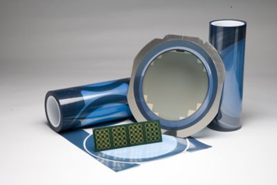 Photo of blue die attach film adhesive in rolls and on components