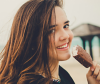 Woman with dirty brunette hair eating an ice cream