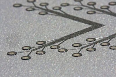 Closeup photo of loctite 1006 a silver electrically conductive ink creating a v-pattern on a circuit board