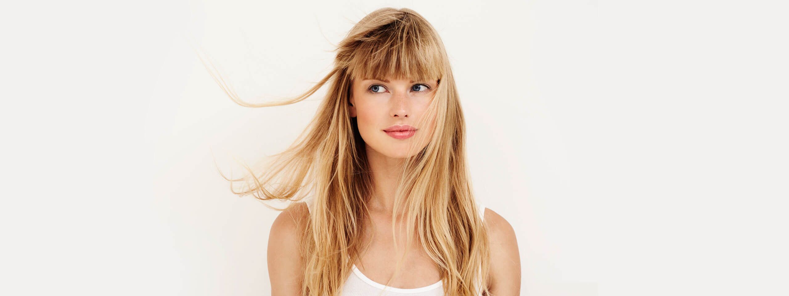 Femme blonde avec frange et cheveux dans le vent
