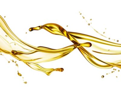 Close-up of gold liquid lubricant splashing in the air