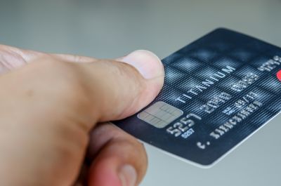 Photo of hand holding a blue credit card with silver colored smart chip as if ready to make a payment shutterstock ID 131264774