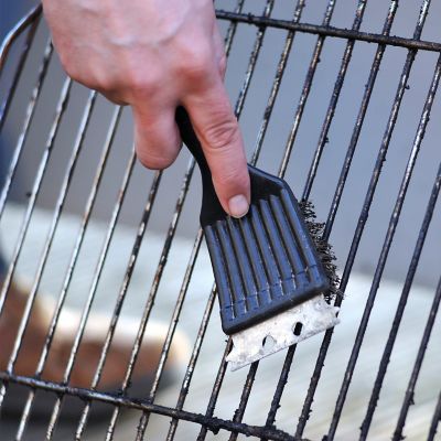 Cleaning the barbecue grate with a steel brush