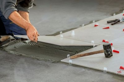 A worker installing tiles over a sealed surface