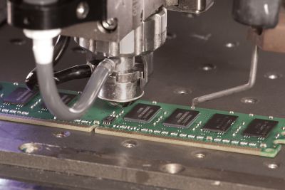 Photo of automation equipment jet dispenser dispensing underfill on a RAM memory board