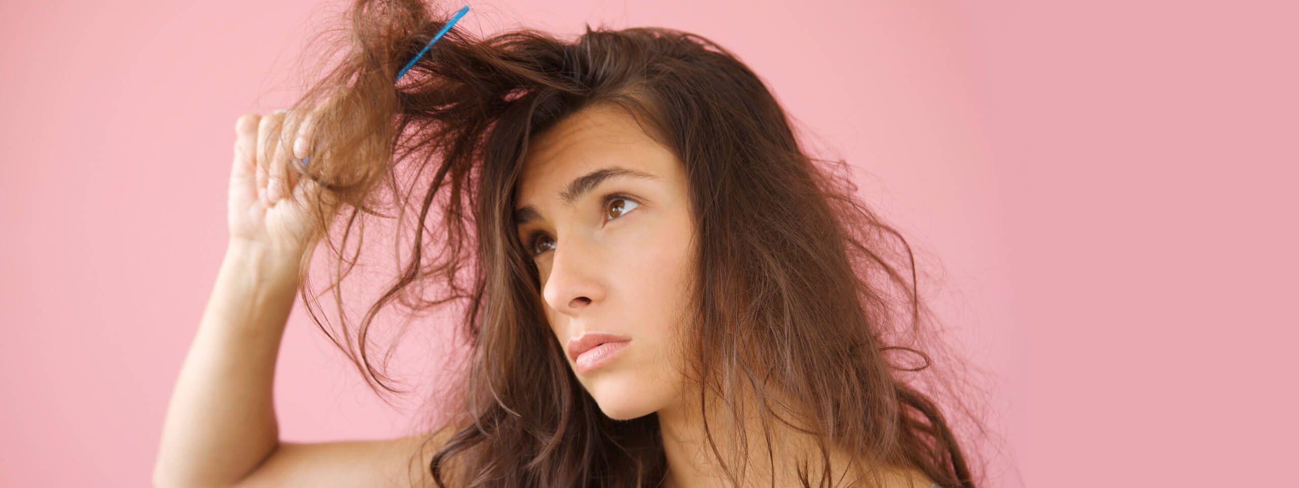Kobieta czesząca zniszczone potargane włosy