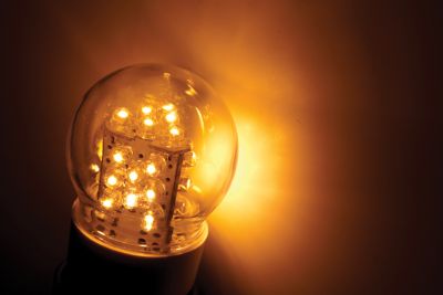 Photo of led light bulb with multiple filaments surrounded by a golden hue shutterstock ID 78199363