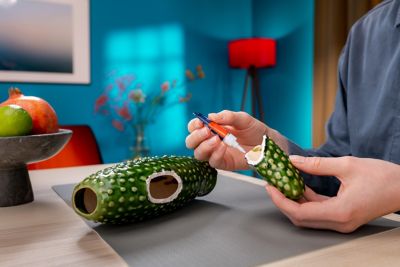 Hand brengt secondelijm aan op een kapotte decoratiecactus van keramiek.