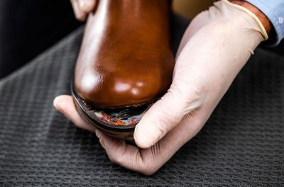 Male hands holding broken leather shoe