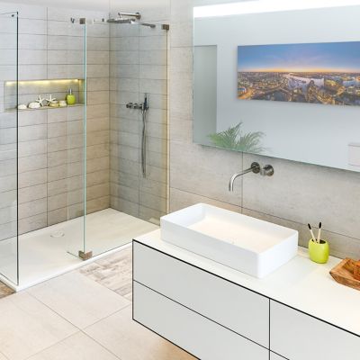 A clean bathroom with a shower and a counter with a sink.