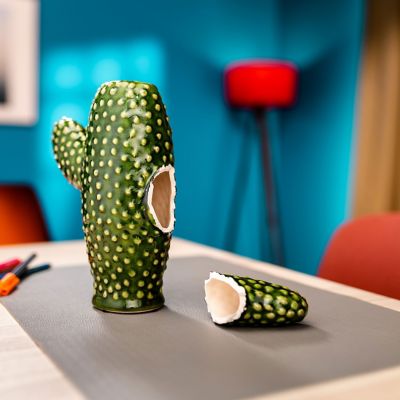 A broken ceramic cactus on a table.