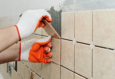 A person installing backsplash tiles