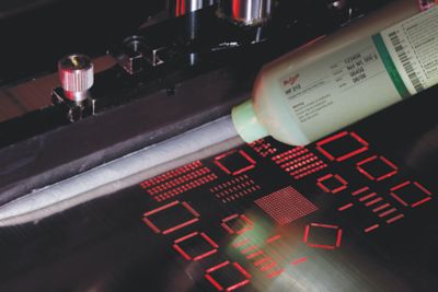 Photo of packaging with label  of mulicore hf212 solder paste being dispensed onto stencil