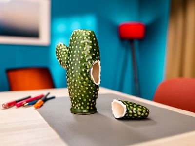 Een beeldje in de vorm van een cactus mist een stukje. Het missende stukje ligt naast het beeldje.